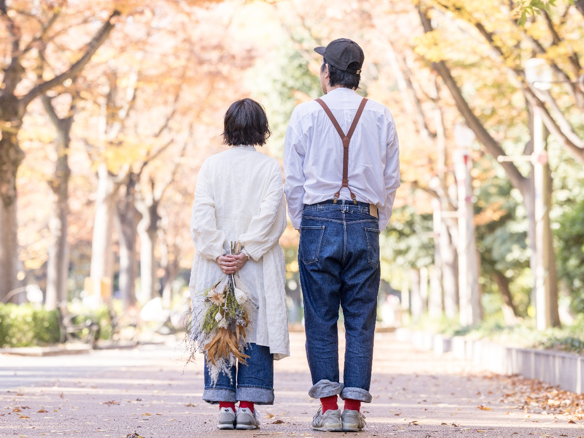 靱公園の並木道でのプチロケーション撮影イメージ｜紅葉の中を歩くご夫婦の後ろ姿（大阪・ミライライト）